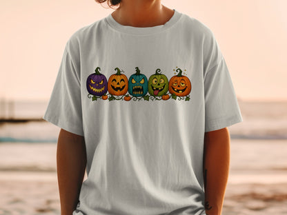 Five cartoon pumpkins with different spooky faces are lined up on a vine.