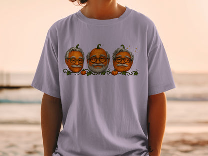 Three pumpkins with elderly faces and glasses are depicted on a t-shirt.