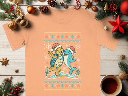 Peach t-shirt with cartoon turtle and dolphin wearing Santa hats.