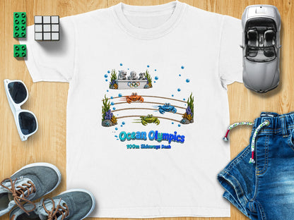 White t-shirt with "Ocean Olympics 100m Sideways Dash" text and cartoon crabs racing.