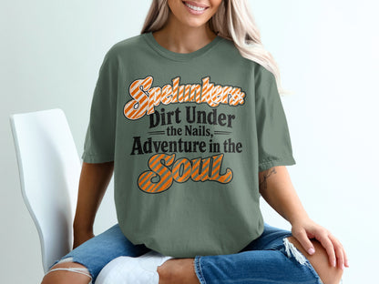 Green t-shirt with text: "Spelunkers Dirt Under the Nails, Adventure in the Soul."