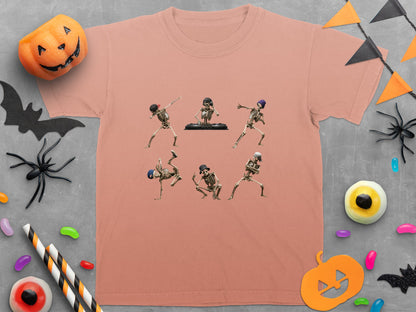 T-shirt with dancing skeletons and DJ skeleton on peach background with Halloween decor.