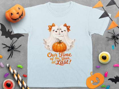 Light blue t-shirt with two ghosts hugging a pumpkin and the text "Our Time of the Year, at Last!".
