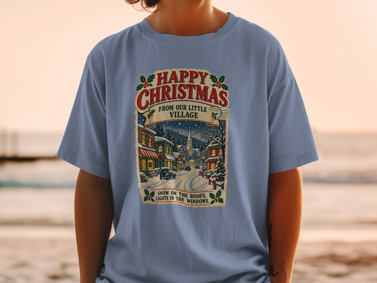 T-shirt with "Happy Christmas From Our Little Village" and winter scene.