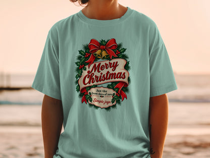Light blue t-shirt with Merry Christmas design, featuring bells and holly.