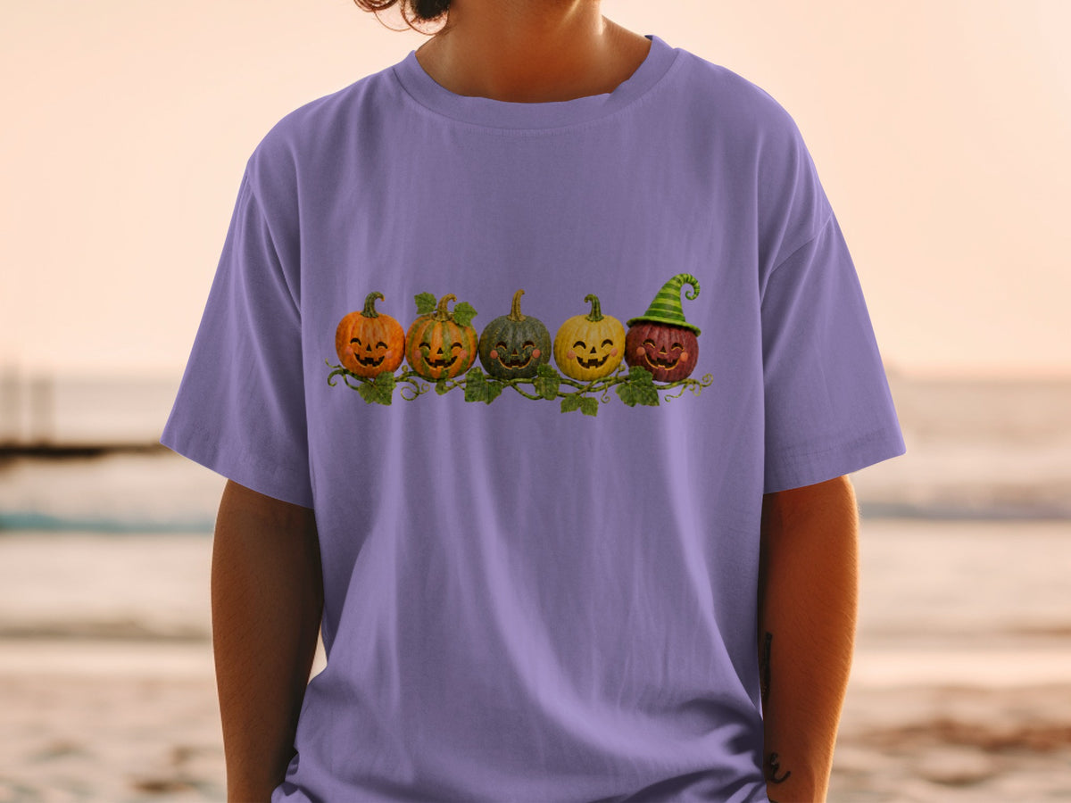 Purple t-shirt with a row of five smiling jack-o'-lanterns with green vines.
