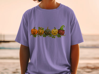 Purple t-shirt with a row of five smiling jack-o'-lanterns with green vines.