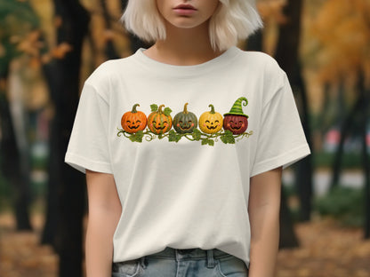 Cream t-shirt with five jack-o'-lanterns and a green striped witch hat.