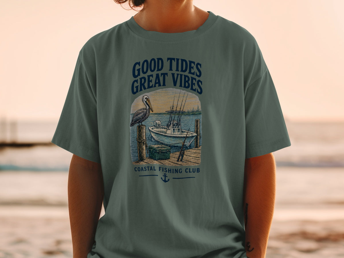 T-shirt graphic with pelican, boat, and text "GOOD TIDES GREAT VIBES COASTAL FISHING CLUB".