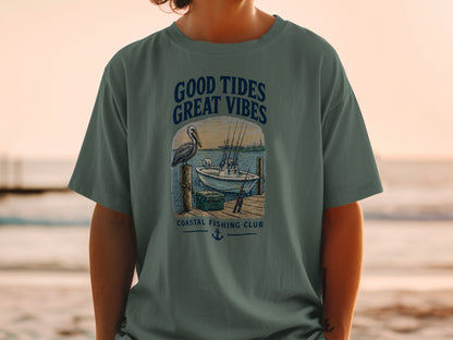 T-shirt graphic with pelican, boat, and text "GOOD TIDES GREAT VIBES COASTAL FISHING CLUB".