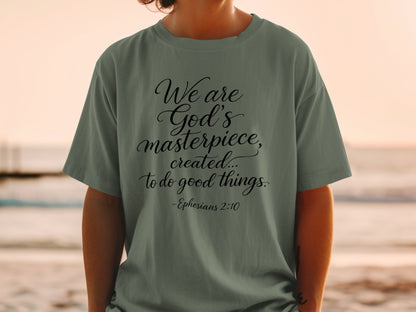 Green t-shirt with black text: "We are God's masterpiece, created... to do good things." - Ephesians 2:10
