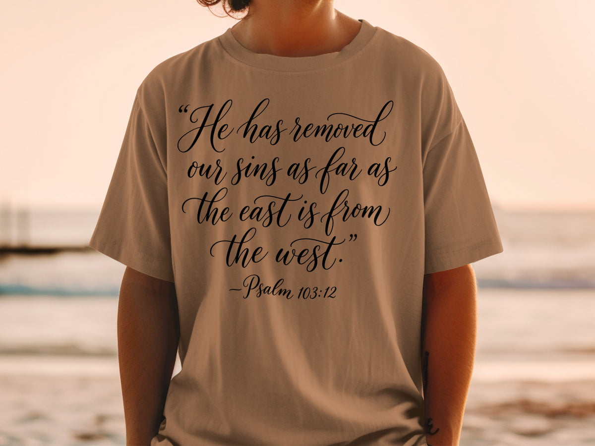 T-shirt with black text: "He has removed our sins as far as the east is from the west." - Psalm 103:12