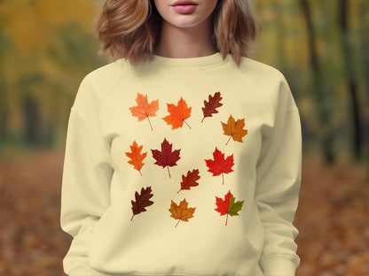 Cream sweatshirt with scattered autumn leaf graphic print.