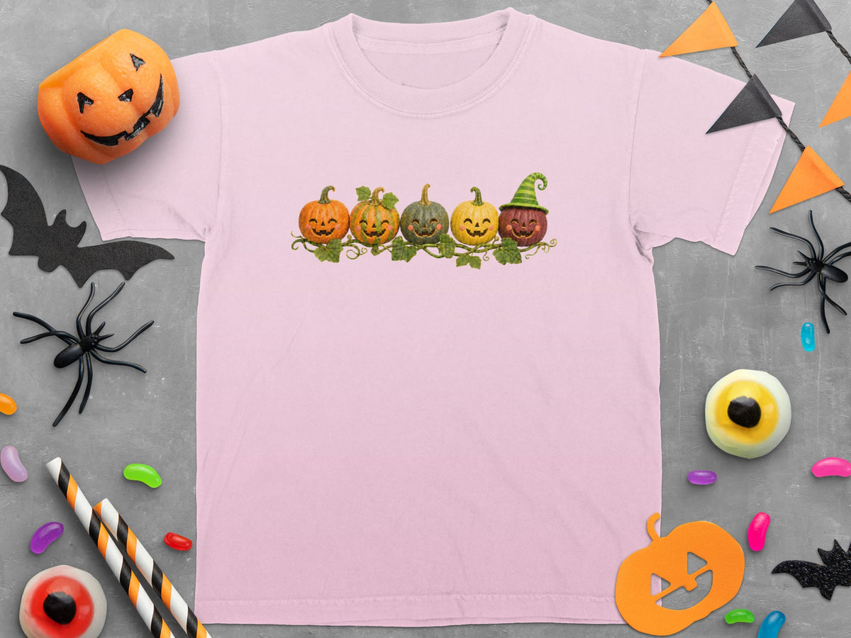 Pink t-shirt with a row of smiling Halloween pumpkins with vines and leaves.