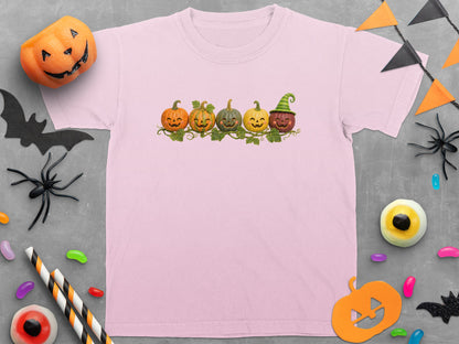 Pink t-shirt with a row of smiling Halloween pumpkins with vines and leaves.