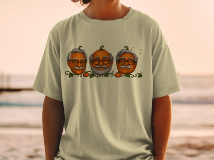 Three pumpkins with faces resembling old men wearing glasses on a t-shirt.