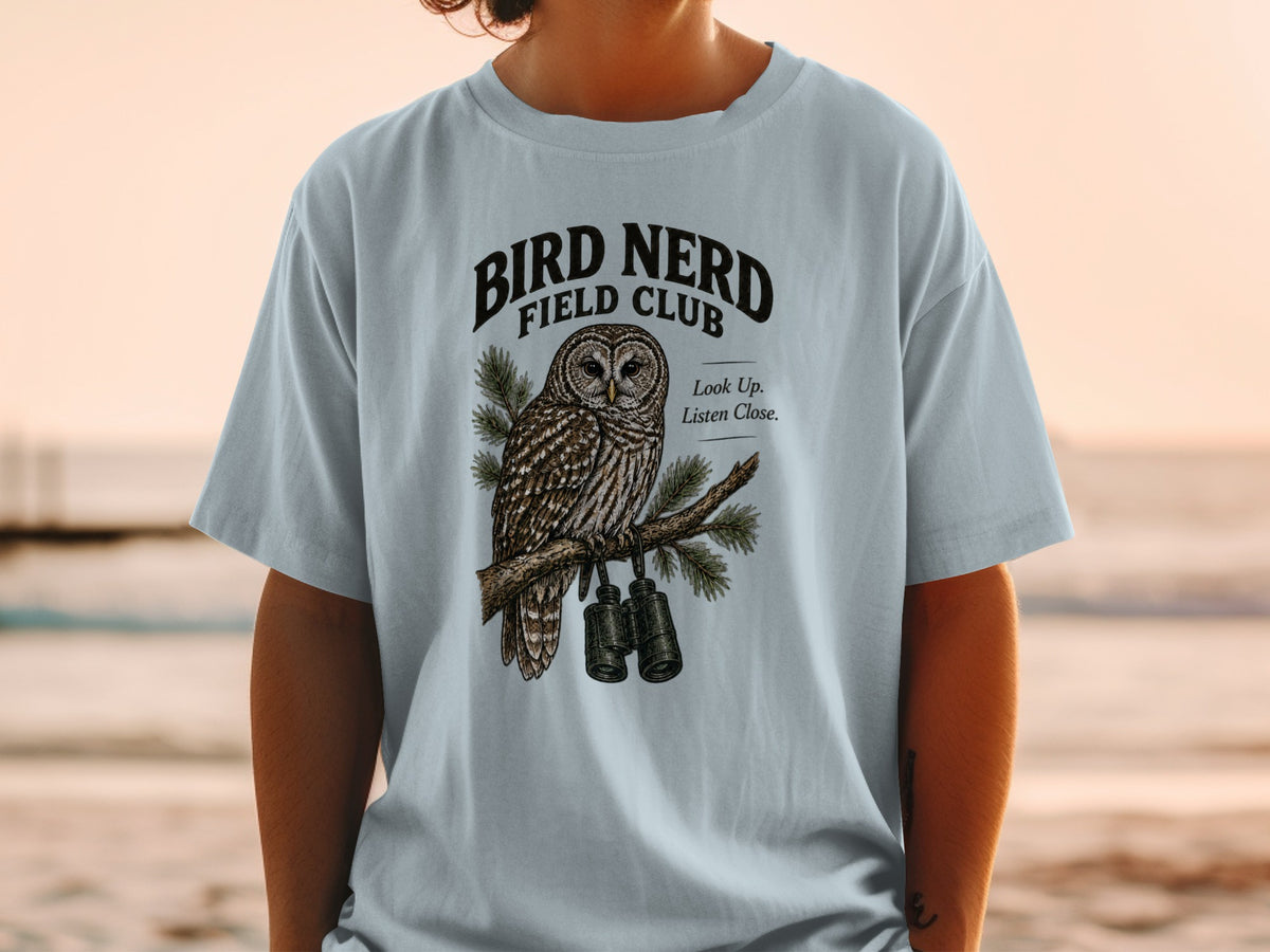Light blue t-shirt with an owl graphic and "Bird Nerd Field Club" text.