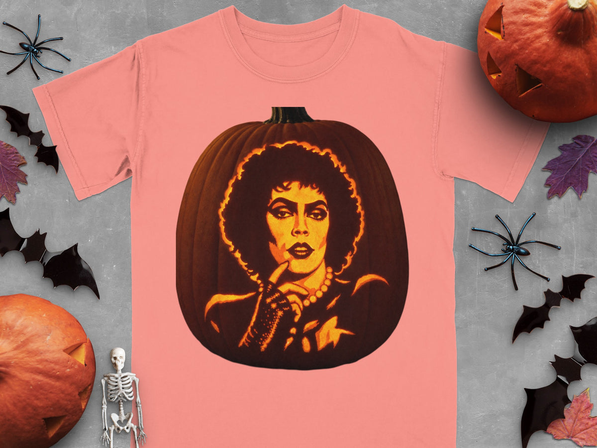 A pink t-shirt displays a carved pumpkin graphic featuring a person with curly hair and a pearl necklace.