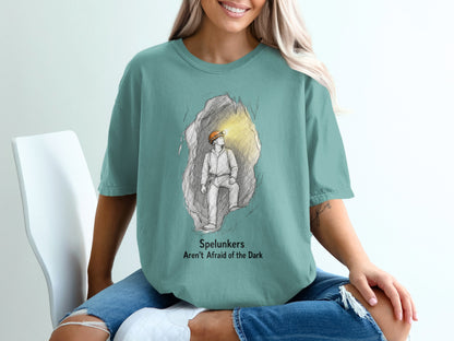 T-shirt with graphic of a caver in a cave and text "Spelunkers Aren't Afraid of the Dark."