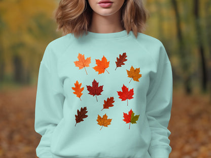 Light blue sweatshirt with an assortment of colorful fall leaves printed on the front.