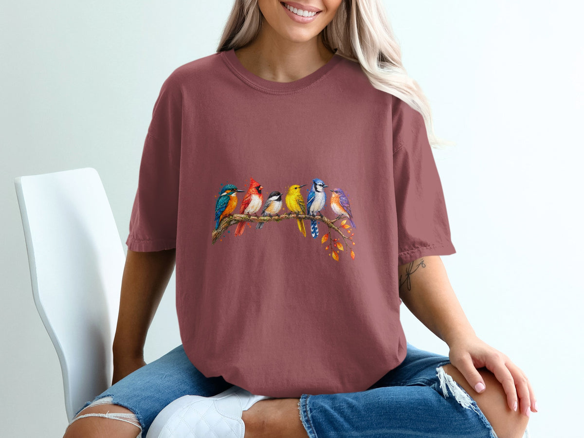 T-shirt with colorful birds perched on a branch with autumn leaves.