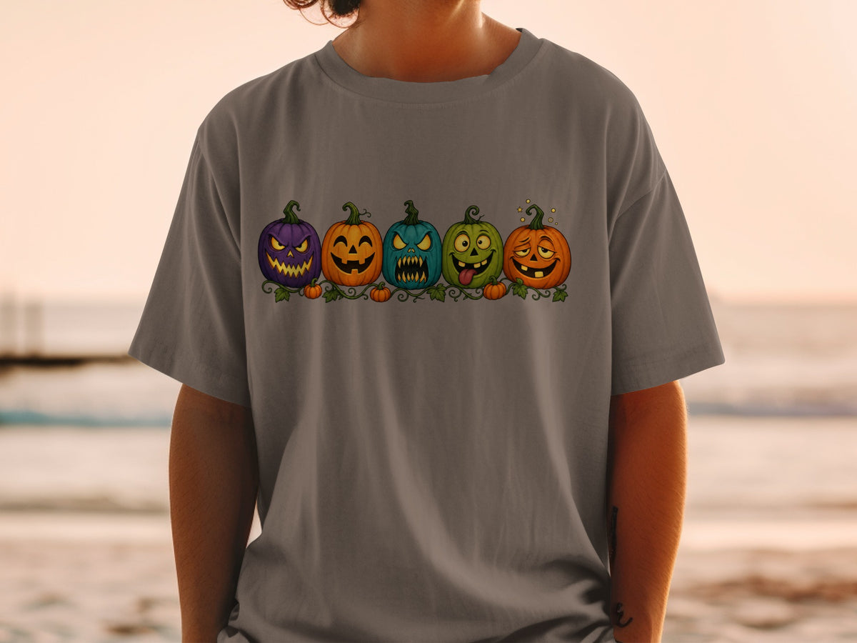 Graphic t-shirt with a row of five cartoon pumpkins with different spooky faces.