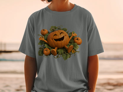 Happy cartoon pumpkin surrounded by smaller pumpkins and green leaves on a grey t-shirt.
