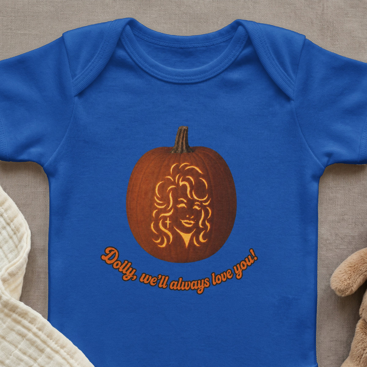 Blue infant bodysuit with a carved pumpkin face and text "Dolly, we'll always love you!"