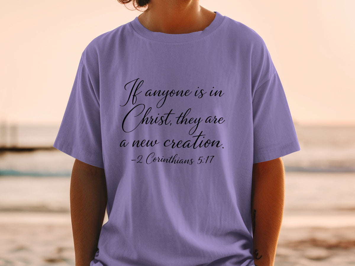 Purple t-shirt with text "If anyone is in Christ, they are a new creation. -2 Corinthians 5:17"