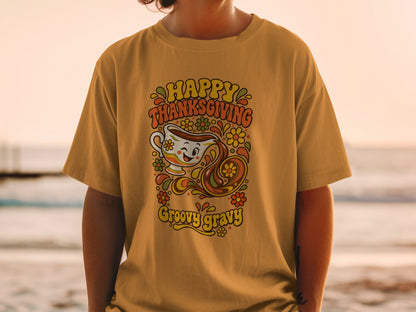 Happy Thanksgiving groovy gravy graphic on an orange t-shirt.