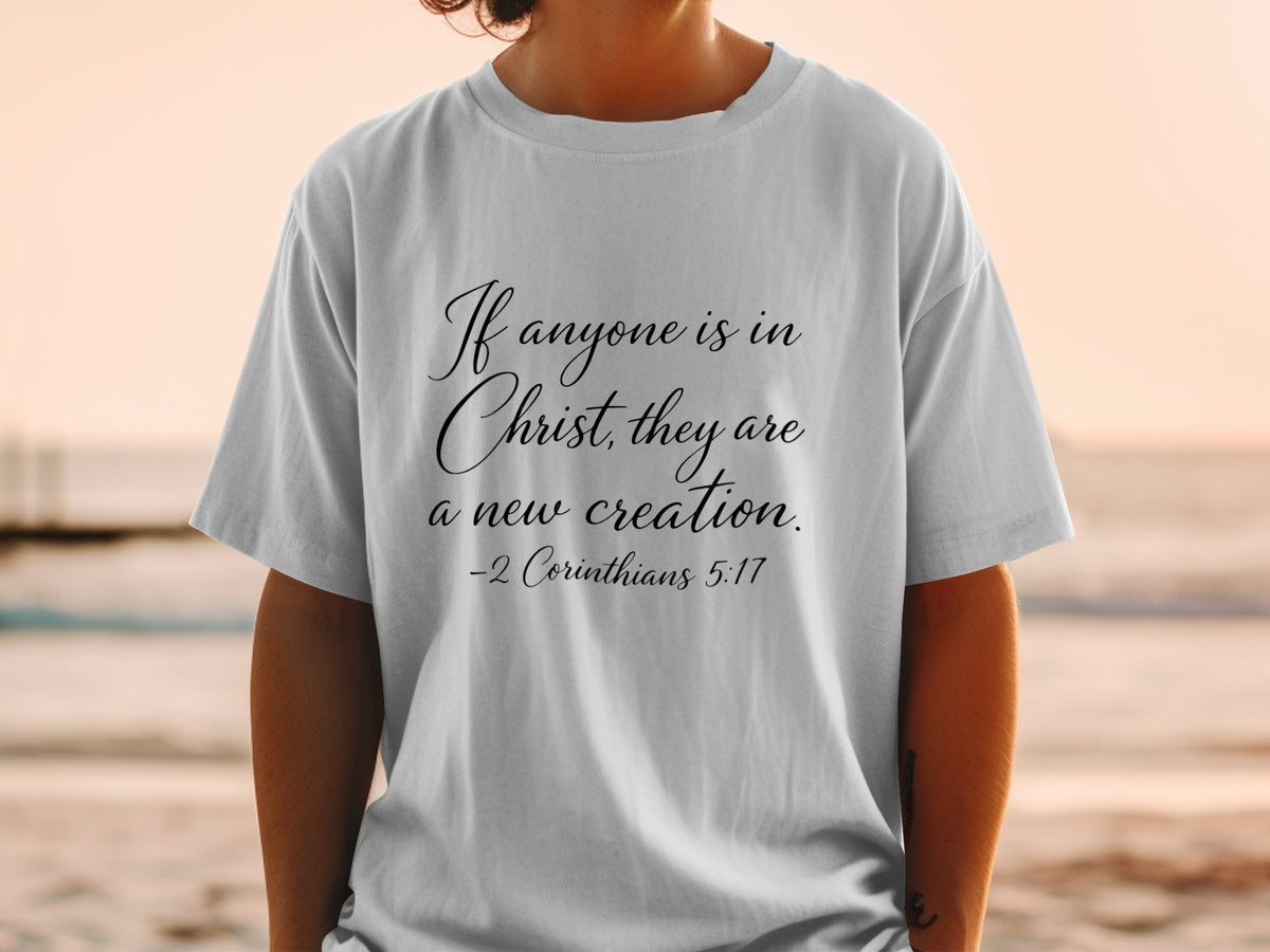 White t-shirt with "If anyone is in Christ, they are a new creation. -2 Corinthians 5:17"