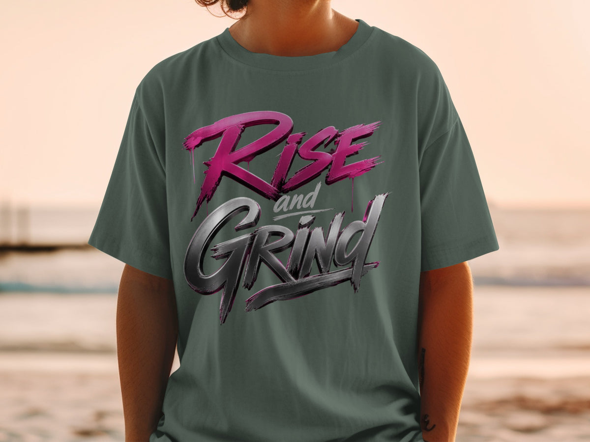Dark green t-shirt with "Rise and Grind" text in pink and metallic silver lettering.