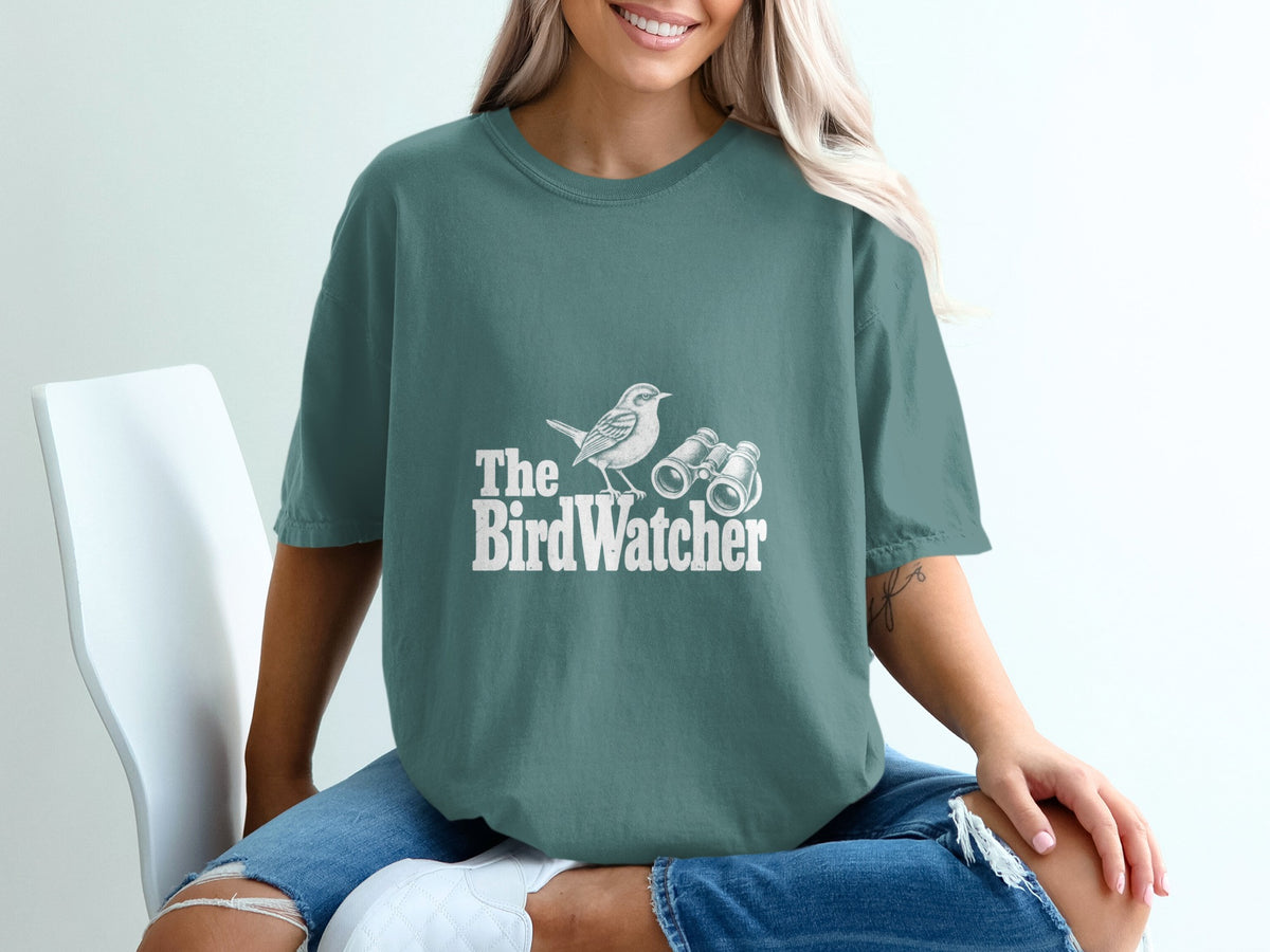 T-shirt with white "The BirdWatcher" text, a bird, and binoculars graphic.