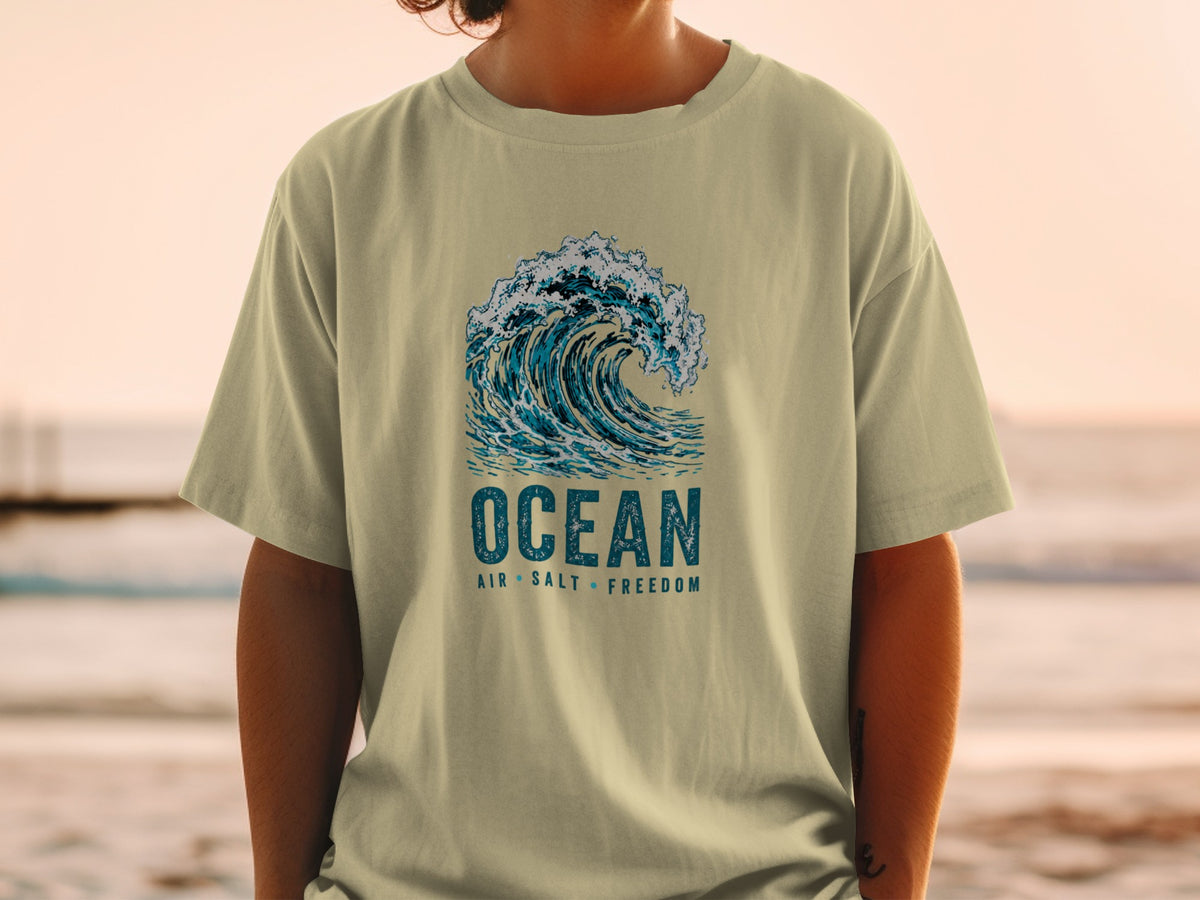 T-shirt with a graphic of a crashing ocean wave and text "OCEAN AIR SALT FREEDOM".