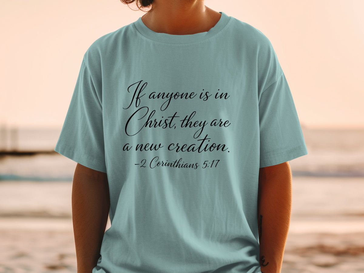 Light blue t-shirt with "If anyone is in Christ, they are a new creation."