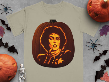 A light olive t-shirt featuring a lit jack-o-lantern carved with a portrait of Frank-N-Furter from The Rocky Horror Picture Show.