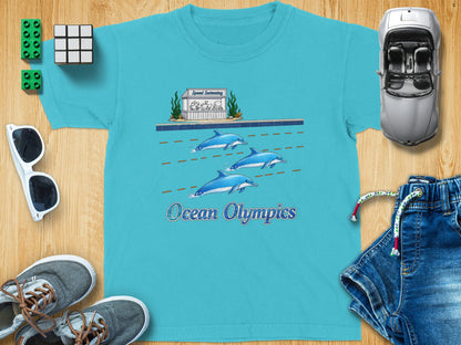 Teal t-shirt with dolphins swimming and "Ocean Olympics" text.