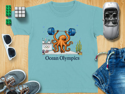 Light blue t-shirt with cartoon octopus lifting weights, "Ocean Olympics" text.