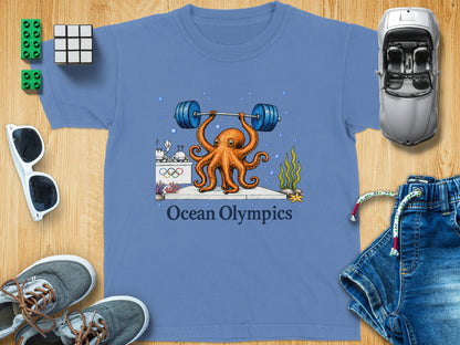 Blue t-shirt with an octopus lifting a barbell, Olympic rings, and "Ocean Olympics" text.