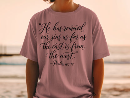 Mauve t-shirt with black script text: "He has removed our sins as far as the east is from the west." - Psalm 103:12