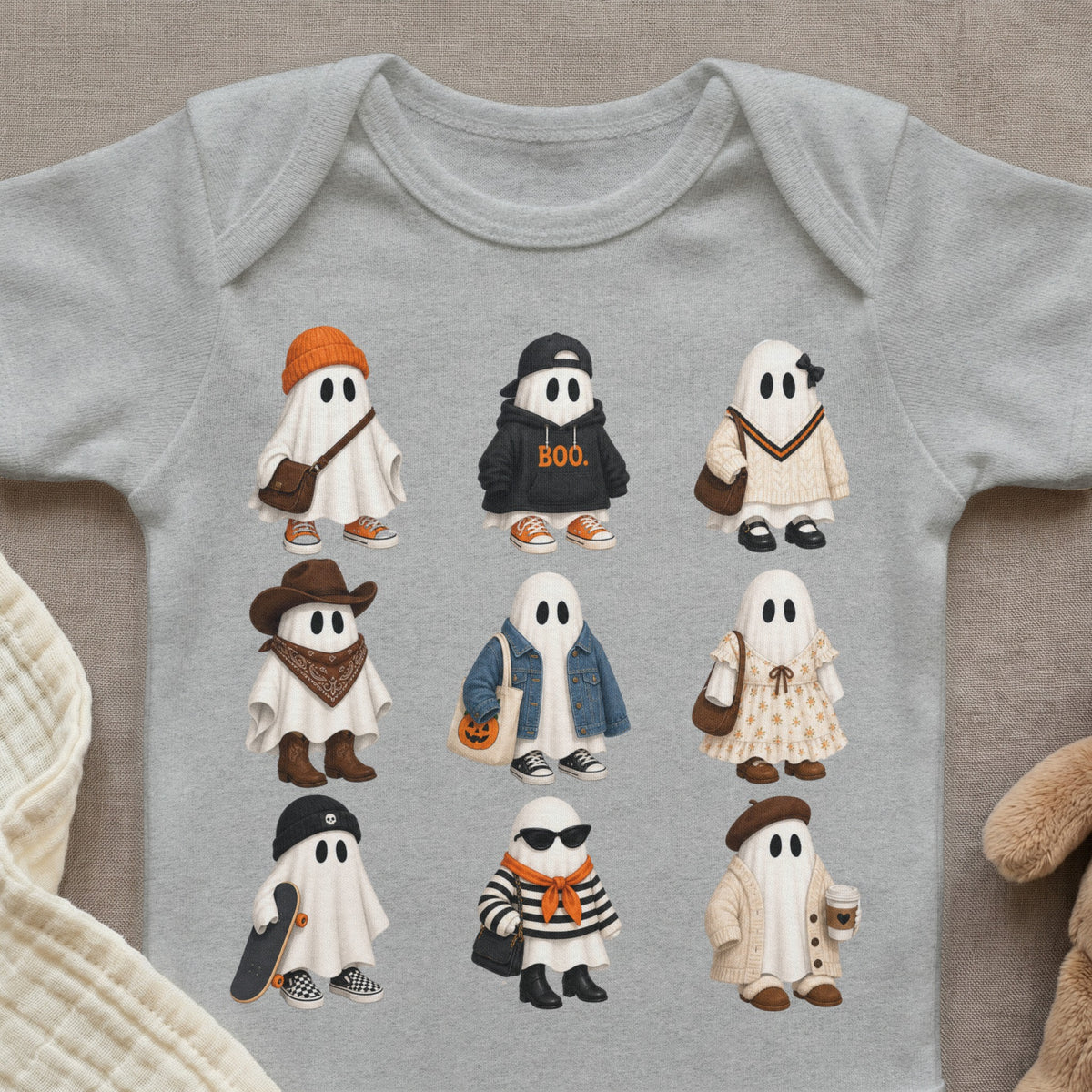 Nine illustrated ghosts in various Halloween-themed outfits are printed on a gray baby onesie.