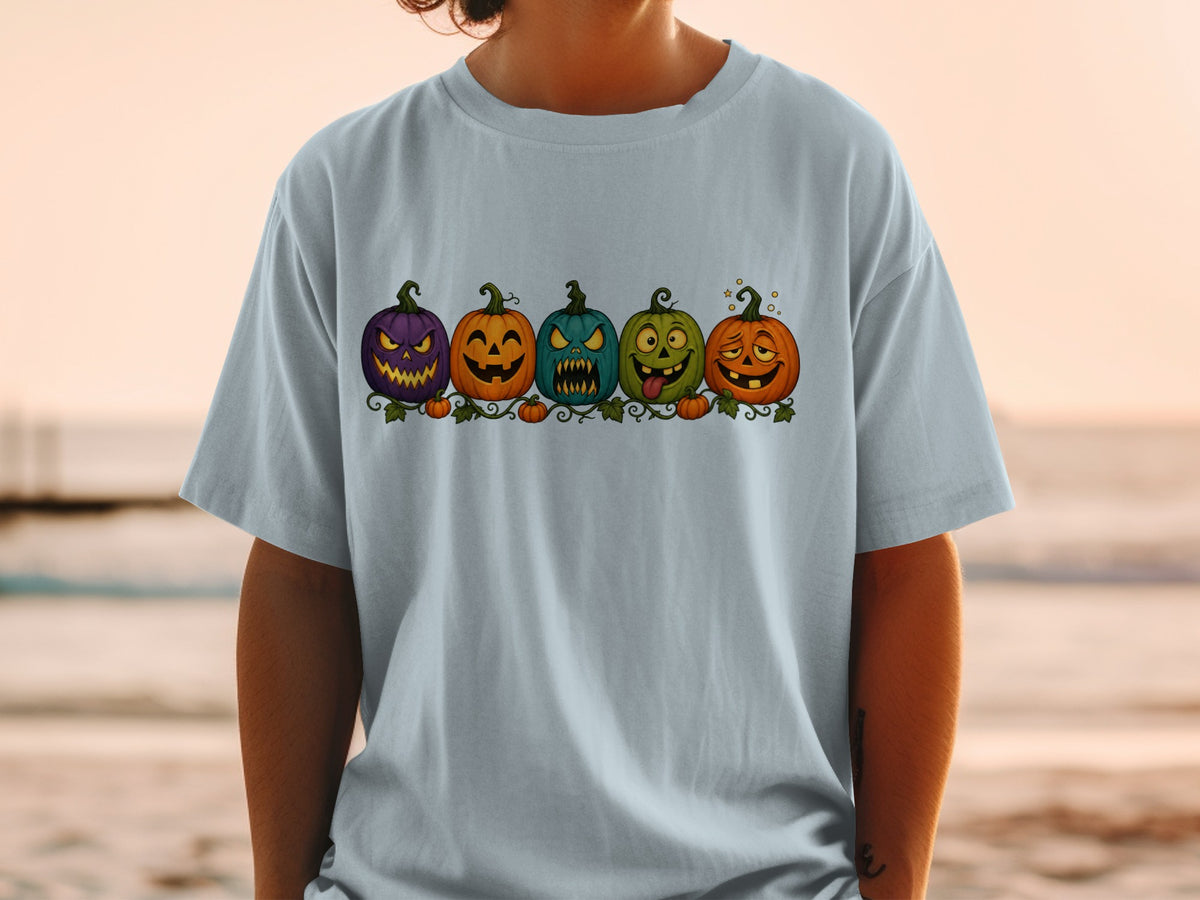 T-shirt featuring a line of five cartoon pumpkins with expressive faces.