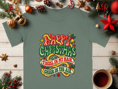 Green t-shirt with "Happy Christmas Tinsel in My Hair Cheer in the Air" text.