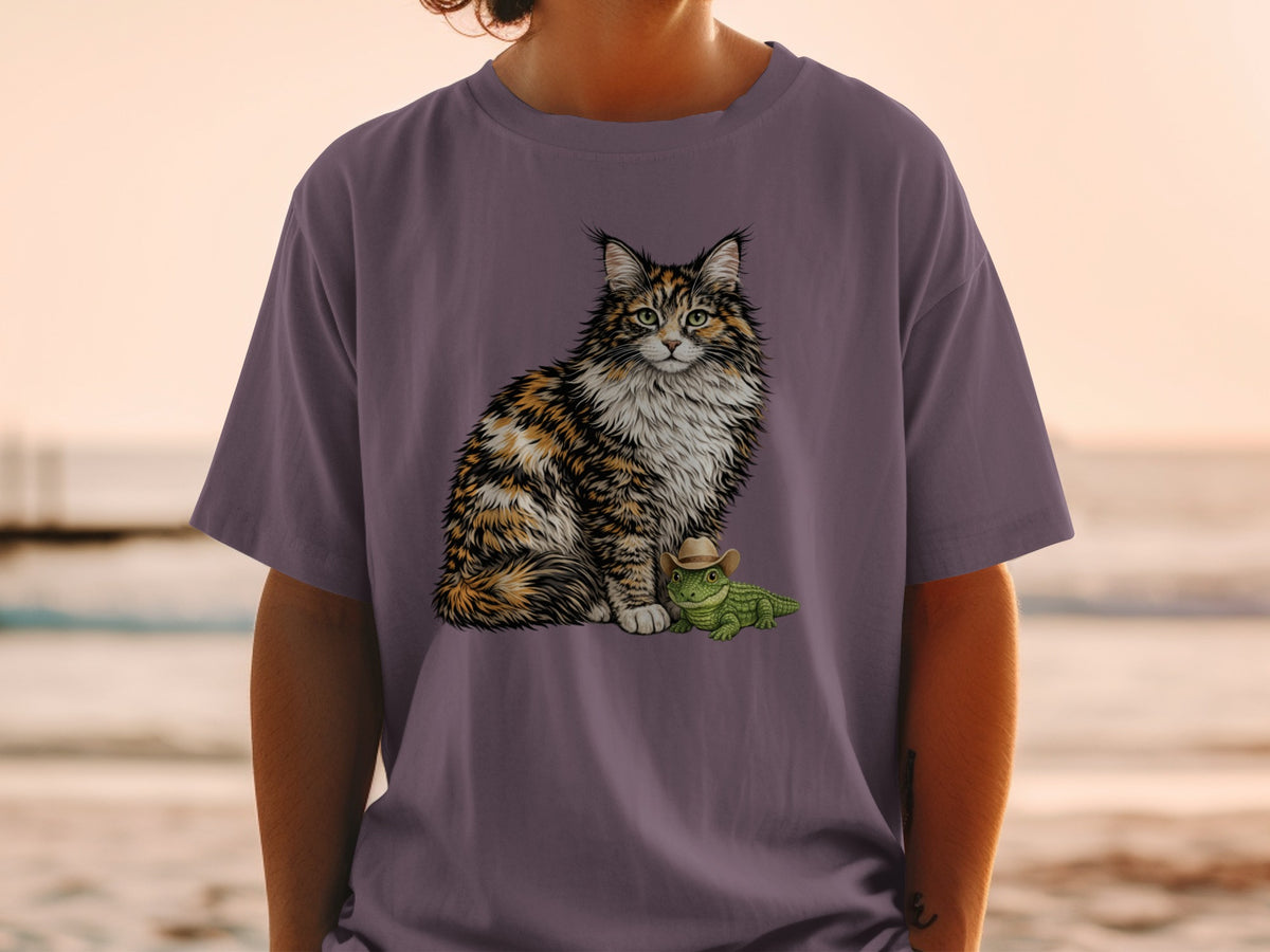 A person wears a purple t-shirt printed with a fluffy calico cat sitting beside a small green alligator wearing a cowboy hat.