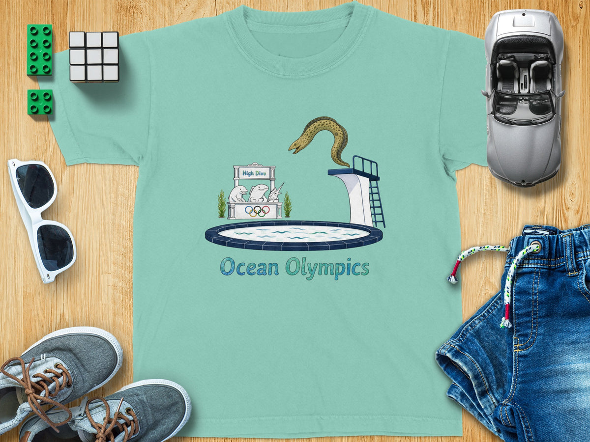 Teal t-shirt with "Ocean Olympics" text and a cartoon of marine animals at a high dive.