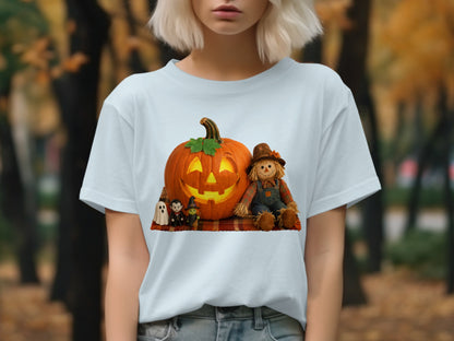 White t-shirt with a Halloween graphic featuring a jack-o'-lantern, scarecrow, and small figures.
