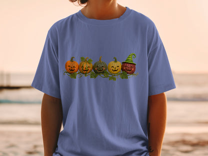 Five smiling carved pumpkins with a witch hat sit on a vine.