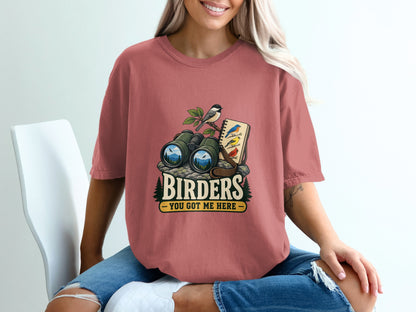 Binoculars, notebook with birds, and text "BIRDERS YOU GOT ME HERE".