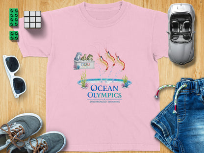 Pink t-shirt with "Ocean Olympics Synchronized Swimming" graphic featuring shrimp and sea creatures.