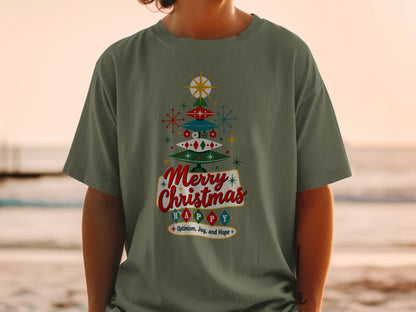 Green t-shirt with a retro Christmas tree graphic and text: Merry Christmas HAPPY Optimism, Joy, and Hope.